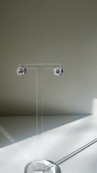 Elegant Tiffany round stud earrings displaying on a clear stand