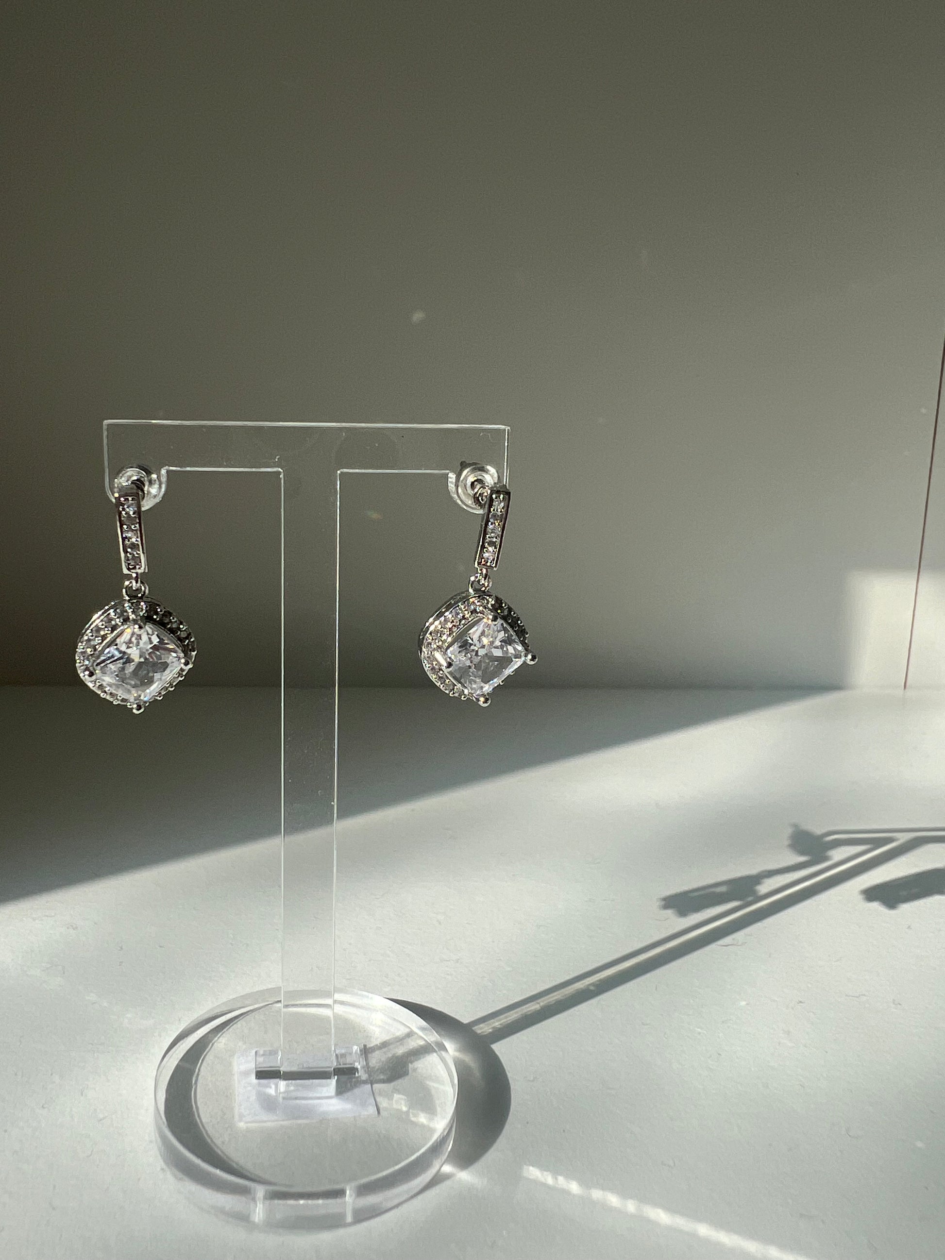 Stylish Daphne earrings displayed on a clear stand