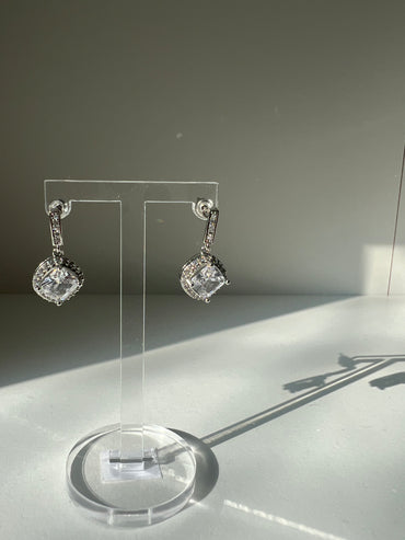 Stylish Daphne earrings displayed on a clear stand
