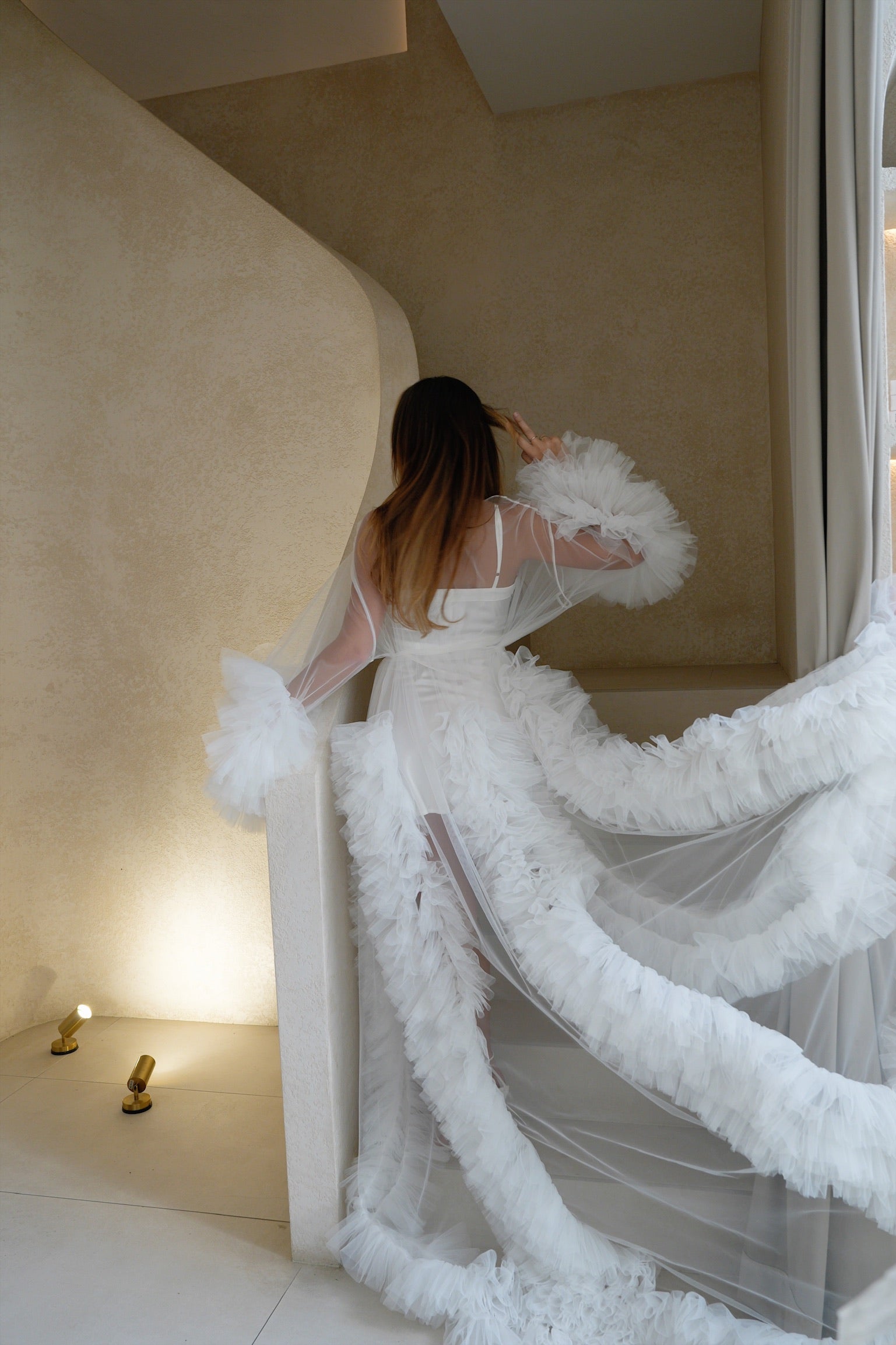 Bride wearing Elenora bridal ruffles robe posing for a photo on a staircase