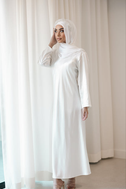 A woman in a white dress and hijab, bridal long sleeve slip