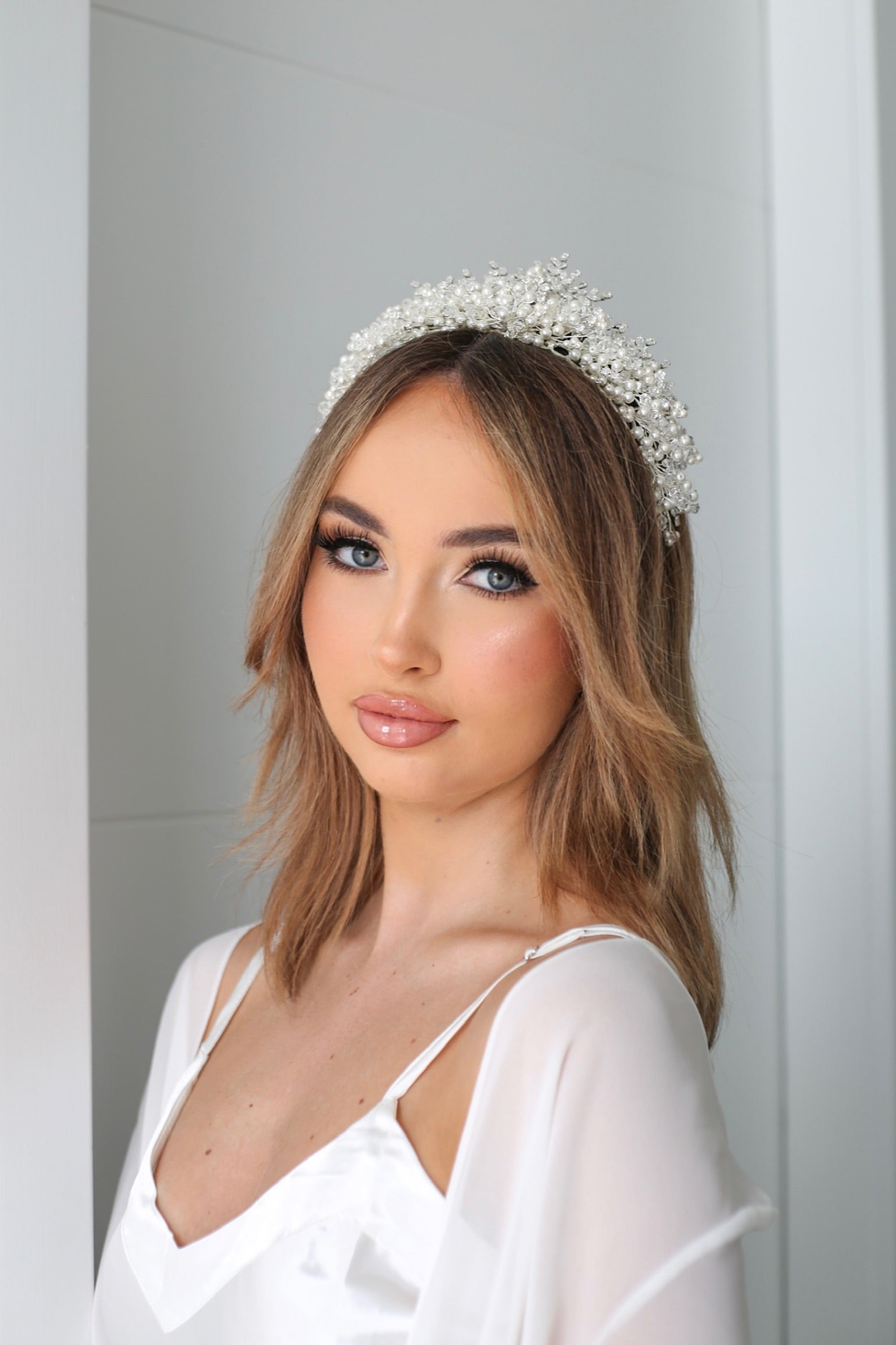 A stunning bride in a white Dilara tiara with crystals and pearls