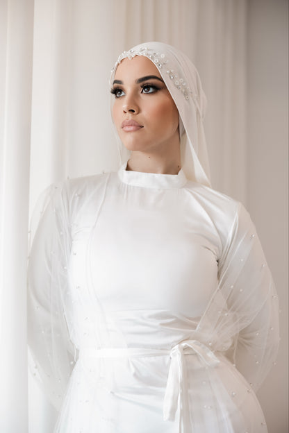 Bridal long sleeve slip worn by a woman in a white dress and veil