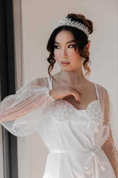 A bride in a wedding dress posing for a photo, wearing Aster crystal tiara