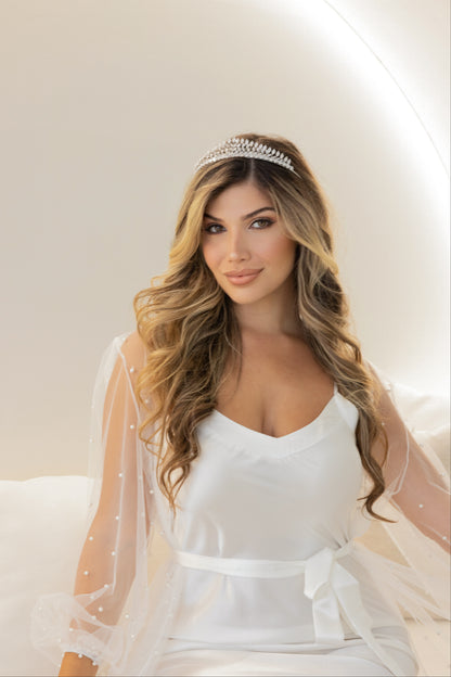 A lovely woman wearing Abby bridal tiara in elegant white dress smiling