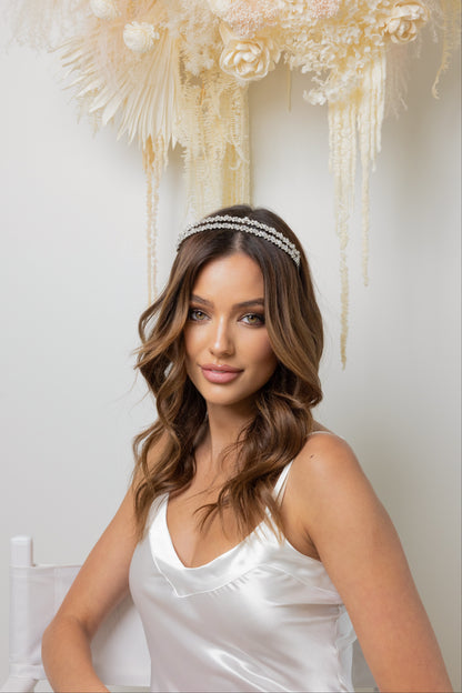 A beautiful woman wearing a white dress wearing stunning headband, looking graceful and stylish