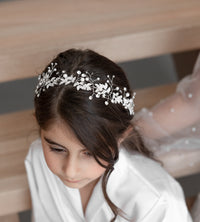 A beautiful girl wearing Celine tiara with pearls and crystals on her head
