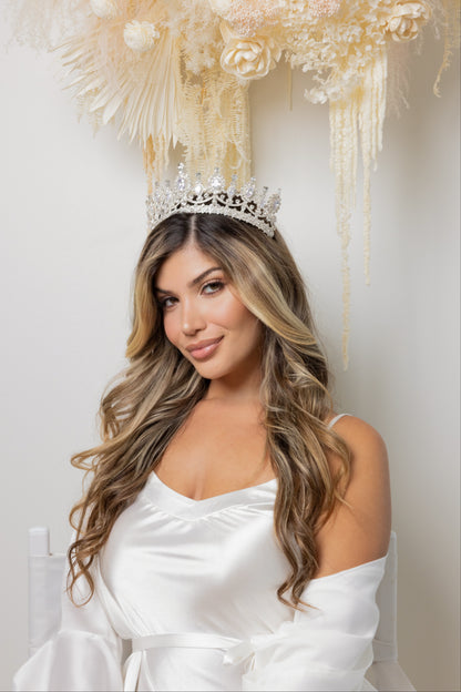 A woman wearing a white dress and Eylul bridal tiara with sparkling crystals